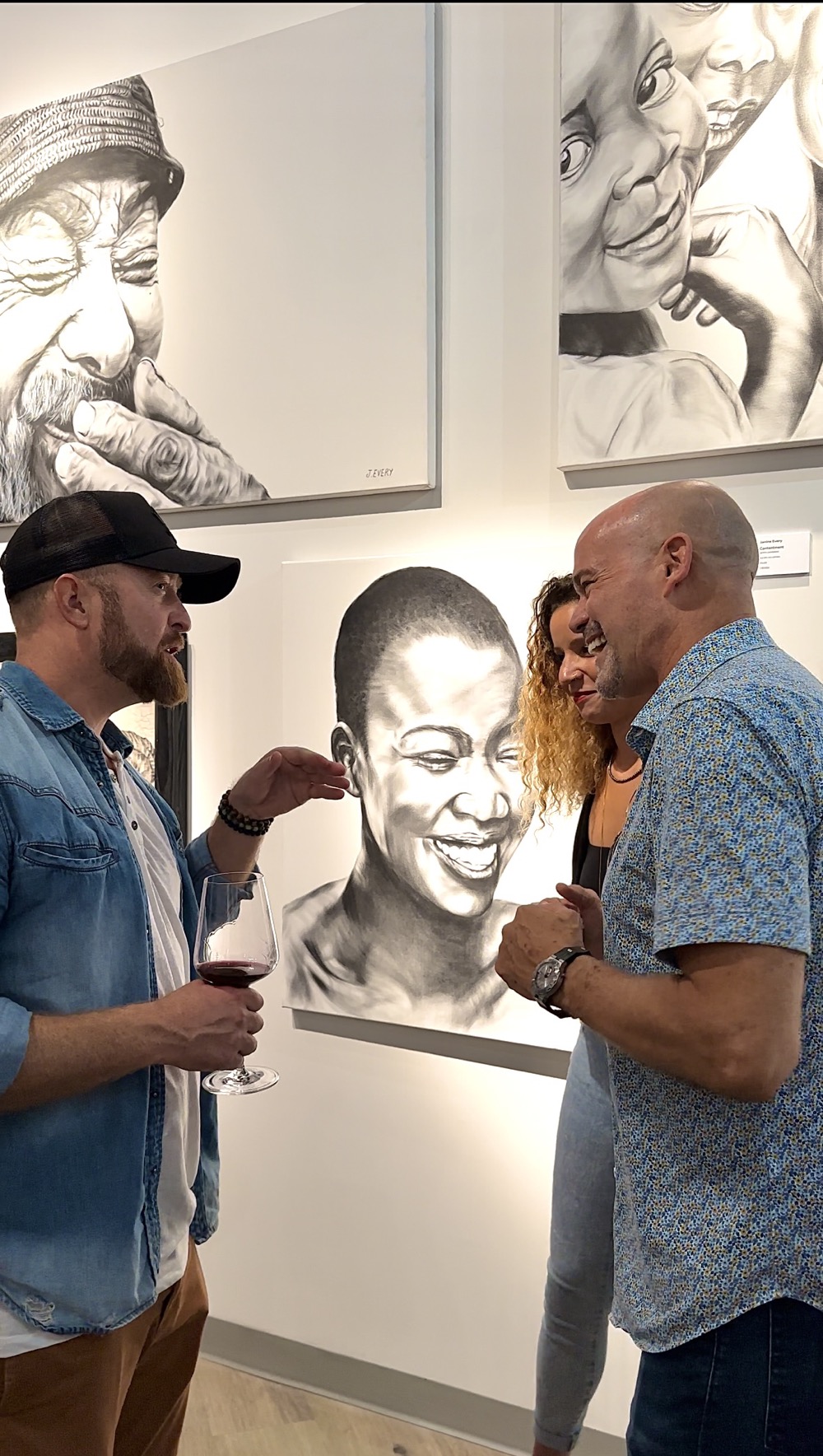 artist talks to viewers at gallery opening
